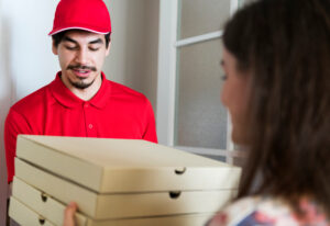 Customer receiving a pizza take-out order from a delivery rider.